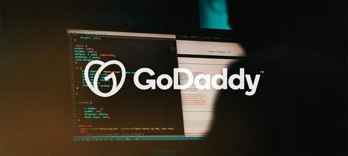 Logotipo de GoDaddy sobre una pantalla con código