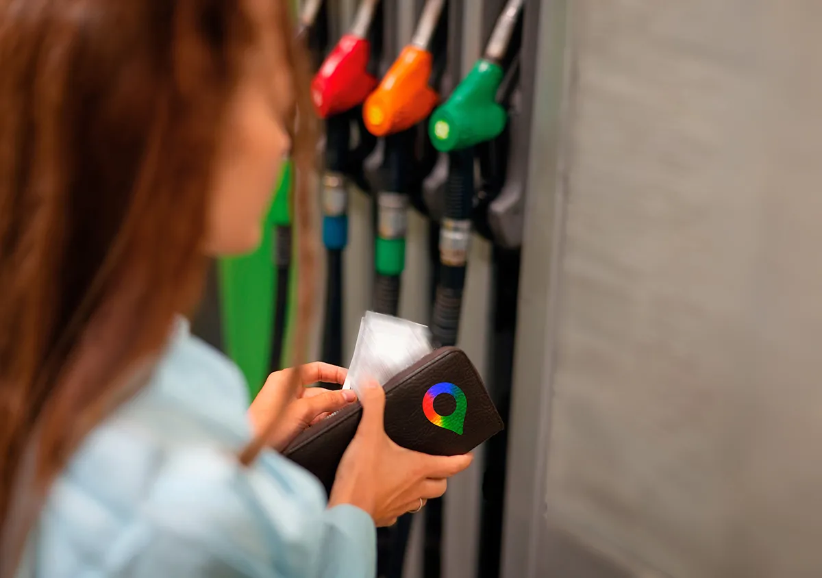 Persona pagando en una gasolinera usando Google Maps para optimizar el consumo de combustible