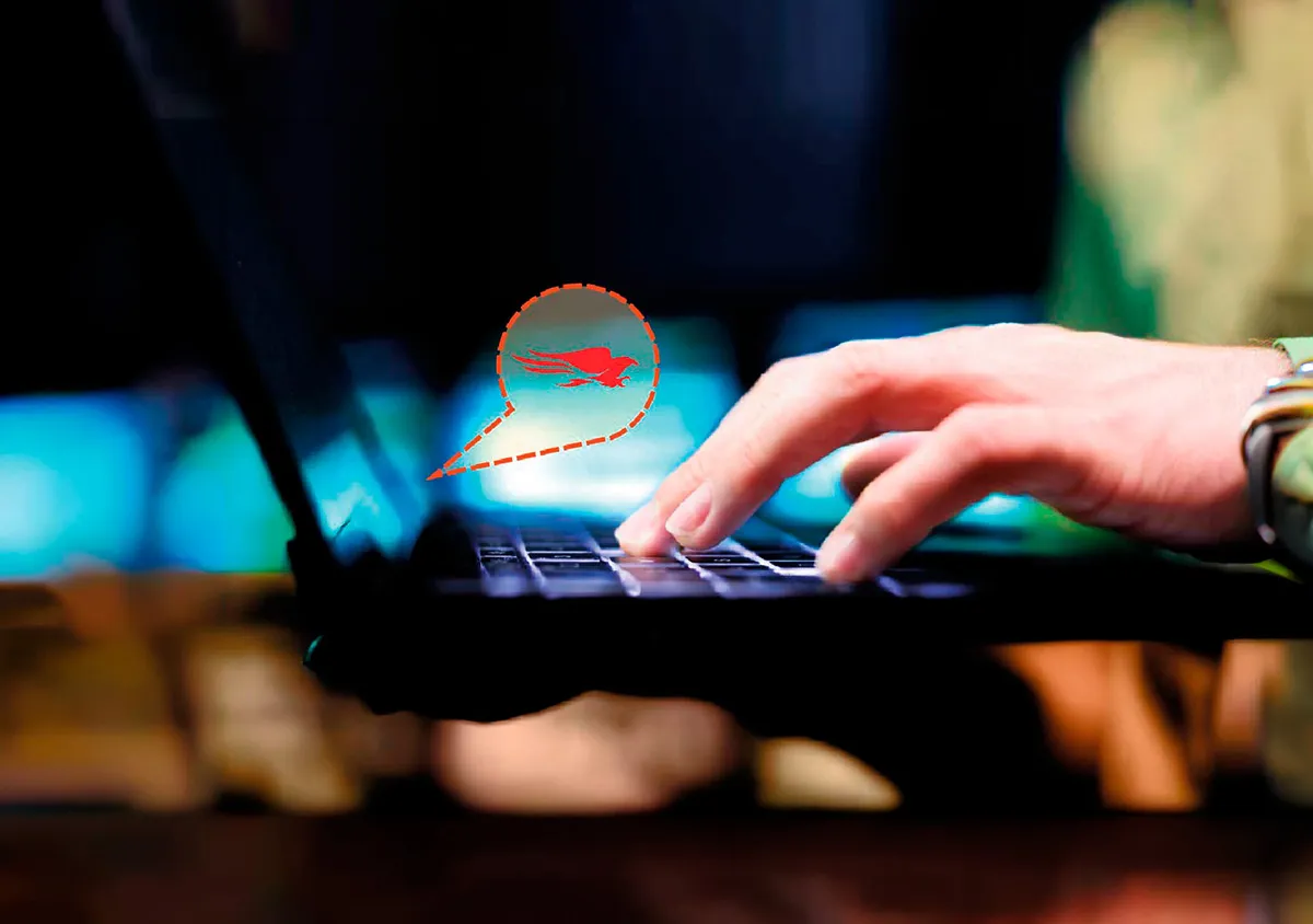 Mano escribiendo en un portátil con icono digital de amenaza ransomware