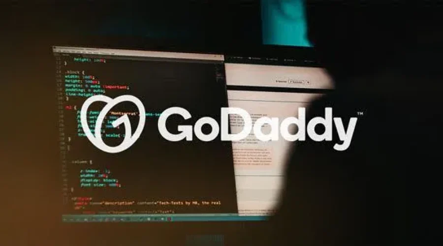 Logotipo de GoDaddy sobre una pantalla con código